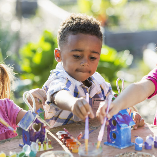 A group of children playing with toys in a garden.